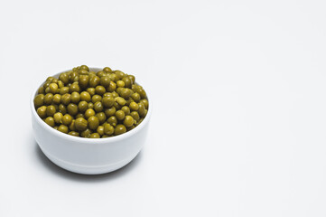 Ceramic white bowl with canned green peas.