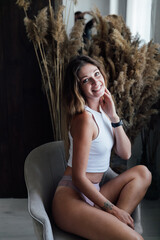Obraz premium Beautiful woman in lingerie sitting on a chair