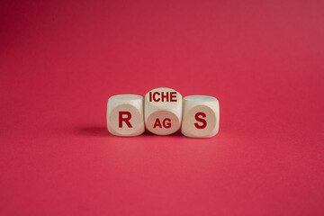 Concept red word Rags Riches on wooden cubes. Beautiful red background. Business and rags or riches concept. Copy space.