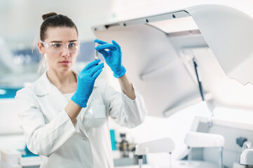 female scientist working in a modern equipped computer laboratory analyzes blood samples and genetic materials using special machines in a modern laboratory