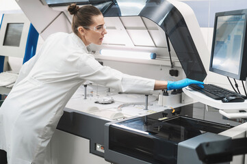 female scientist working in a modern equipped computer laboratory analyzes blood samples and genetic materials using special machines in a modern laboratory