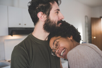 Young multiethnic couple hugging smiling together at home