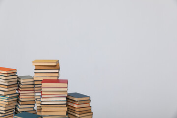 A simple composition of many books, stack or pile of books on wooden table, one of them open with...