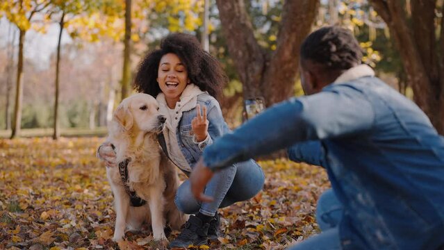 Smiling people playing with dog for video for family archive