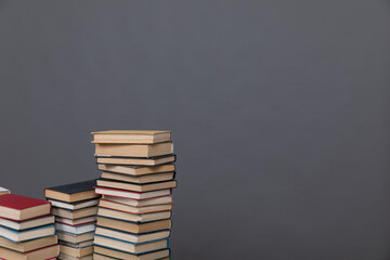 A simple composition of many books, stack or pile of books on wooden table, one of them open with...