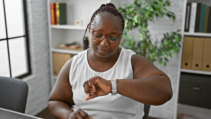 Focused african american business woman worker keeping track of time, relaxed at her stylish office...