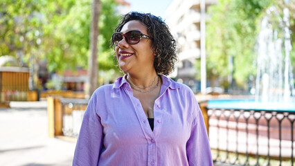 Young beautiful latin woman smiling confident standing at park