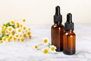 Glass bottle with chamomile essential oil on an old wooden background. Chamomile flowers, close up. Aromatherapy, spa and herbal medicine ingredients. Beauty concept.Copy space. Natural cosmetic