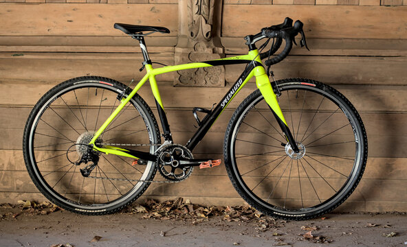 Specialized Crux cyclocross gravel bike leans on wooden wall with arches.