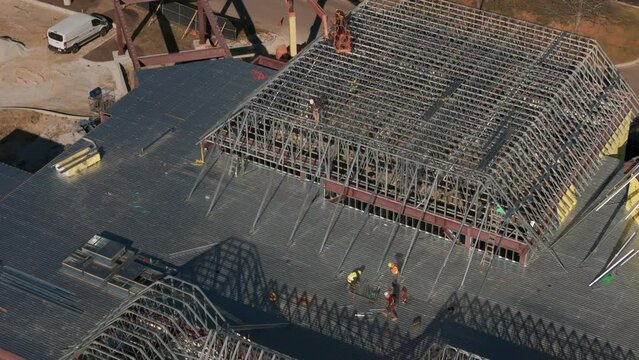 Industrial roof. Roofers installing a new roof on an industrial building or warehouse. Aerial shot