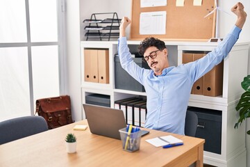 Young caucasian man business worker relaxed stretching arms at office