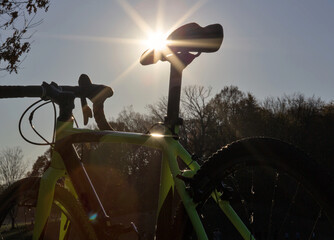 bicycle frame from behind with sun flare over saddle (handlebars, wheels, tires, aluminum gravel...