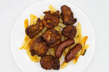 An Overhead View of Japanese Karaage Fried Chicken with Fries and Sausage on a White Plate