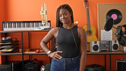 African american woman musician smiling confident standing at music studio