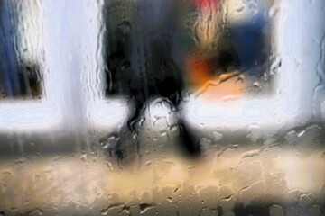 Abstraktes Motiv mit Wassermuster auf Glasscheibe vor schwarz gekleideter Frau auf Gehweg vor Schaufenster mit bunten Stoffen und Licht in Stadt bei Regen am Morgen im Winter