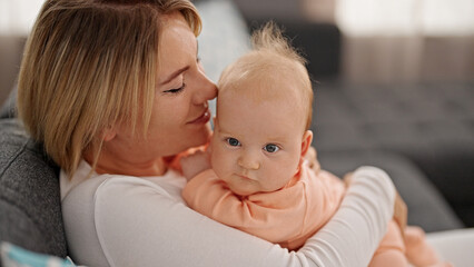 Mother and daughter hugging each other at home