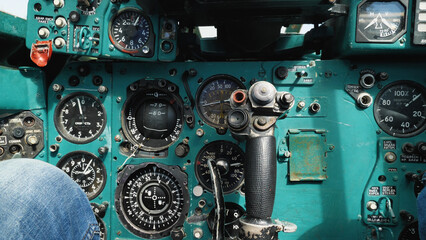 Cockpit of an old Soviet Mig-23 fighter. Close-up of instruments, gauges and controls. Switches, buttons and analogue controls of a decommissioned military aircraft. - obrazy, fototapety, plakaty