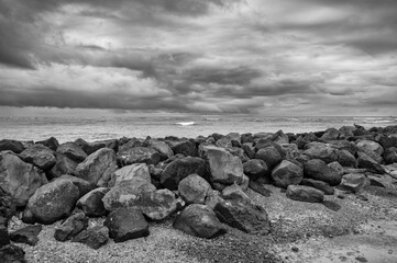 Dark Clouds over the Ocean with a Sea Wall in the Foreground.
