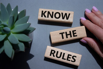 Know the rules symbol. Wooden blocks with words Know the rules. Businessman hand. Beautiful grey...