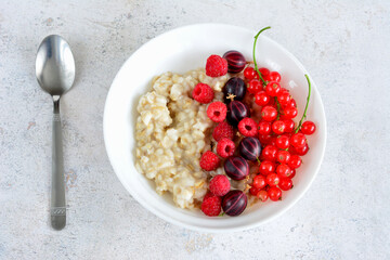 porridge with raspberry, gooseberry and red currant top view  