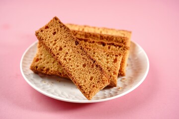 Homemade Indian cake rusk | Dry biscuits isolated on pink background, selective focus