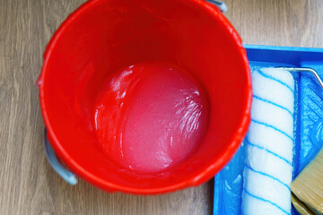 Translucent wallpaper glue in a red bucket