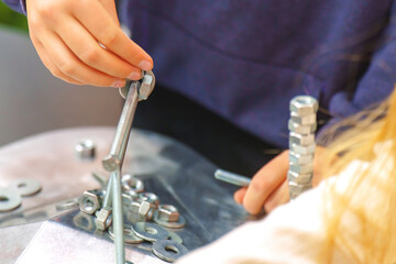 Fototapeta premium Children assembling figures from nuts and bolts on a magnetic table