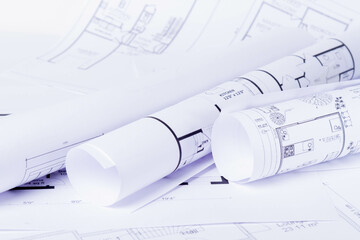 Construction plan. Scheme drawing rolled up in a roll. Home renovation planning.