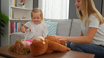 Happy caucasian mother and little daughter comfortably enjoying and playing with toys at home, resting on the sofa