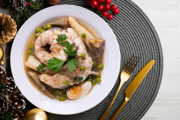 Conger eel with white asparagus and egg. Traditional Spanish tapas. Christmas food served on a table decorated with Christmas motifs.