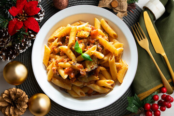 Pasta alla norma traditional italian recipe. Dish served on a table with christmas decoration.