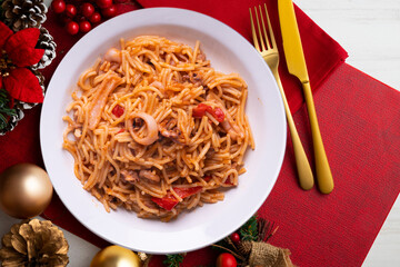 Fideua with squid and seafood. Typical Spanish tapa cooked with paella. Christmas food served on a table decorated with Christmas motifs.