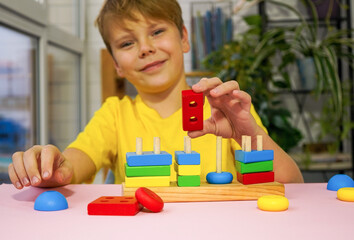 eco wooden toys. The child collects a sorter. Educational logic toys for kids. Games for Child Development