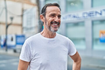 Middle age man smiling confident looking to the side at street