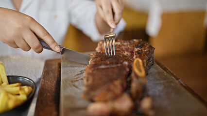 Young woman carving meat at the restaurant