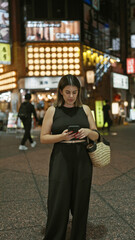 Beautiful hispanic woman engrossed in a serious phone conversation, using her smartphone on tokyo's...