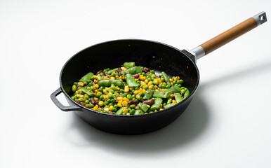 healthy vegetables, beans and corn in a frying pan isolated on a white background