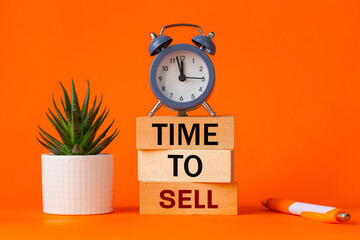 Time to sell symbol. alarm clock and time to sell, word concept on wooden blocks. Beautiful orange background, succulent on desk, business and sales concept. Copy space - obrazy, fototapety, plakaty