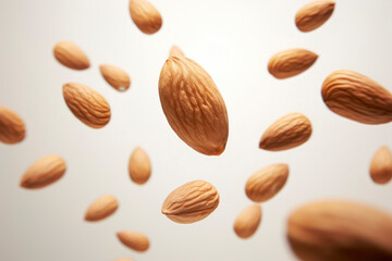 Almonds fall in pile on gray gradient background. Creative concept of floating healthy snacks. Background of falling almonds. Levitation of nuts. Close-up. Copy space.