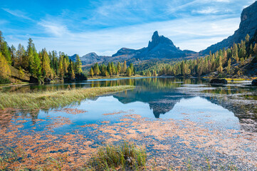 Iconic rocky dolomite mountains near an alpine lake in autumn