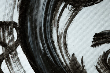 Dark brush strokes on a textured canvas. Black and white abstract background. A fragment of an...