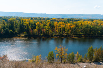 Top view from the mountain to the beautiful autumn forest and river