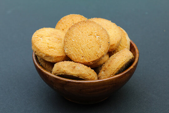 Osmania biscuits in a wooden bowl on black background close-up view 