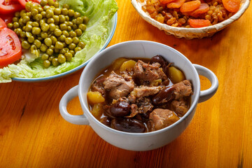 Lamb stewed with potatoes in spices and sauce next to dried fruits and vegetables for iftar meal