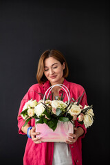 Happy woman holding a bouquet of flower isolated on black background	