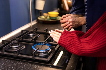 Freezing couple warming close to gas oven. Cold winter and high price taxes concept	