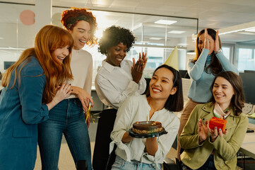 A birthday surprise at office with diverse female colleagues.