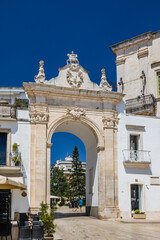 Fototapeta na wymiar Martina Franca, Taranto, Puglia, Italy. Village with baroque architecture. The Santo Stefano Gate gives access to the city center. Sunny day in summer.