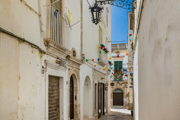 Martina Franca, Taranto, Puglia, Italy. Village with baroque architecture. The narrow alleys of the city and the buildings with their characteristic balconies. Blue sky on a sunny day in summer.