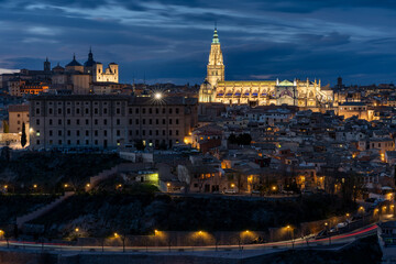 Fototapeta na wymiar Panoramic view of the historic center of Toledo, Spain, at night with its illuminated Santa Maria Cathedral and San Ildefonso Church. UNESCO World Heritage Site